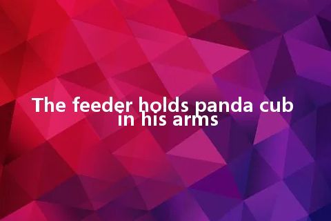 The feeder holds panda cub in his arms